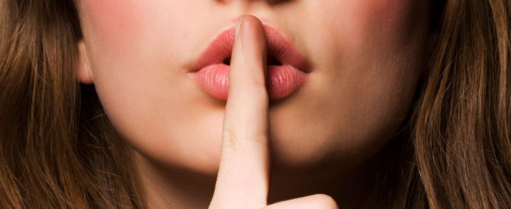 Vrouw houdt haar vinger op haar lippen