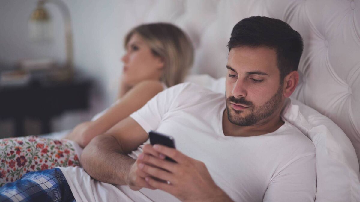 Man with phone in bed