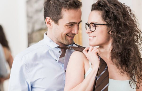 Woman pulls man's tie and laughs