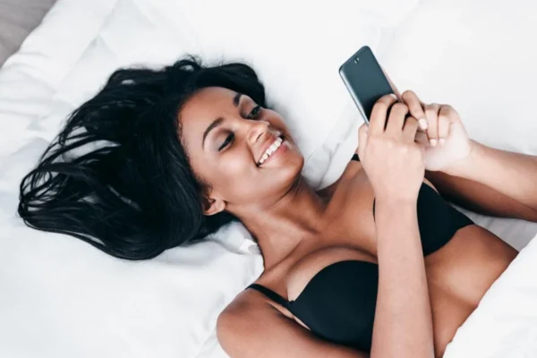 Sexy woman on bed with her phone