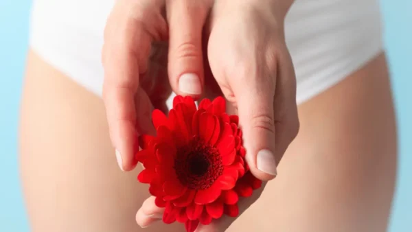 Vrouw met een rode bloem tussen haar benen