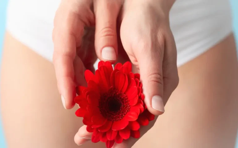 Vrouw met een rode bloem tussen haar benen
