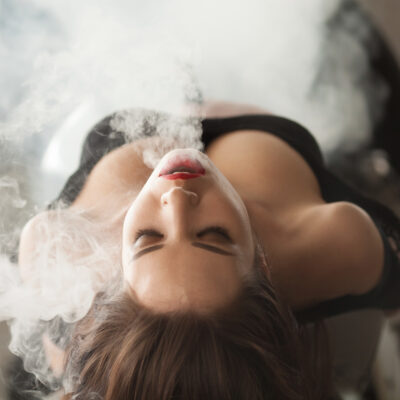 Young beautiful woman vaping