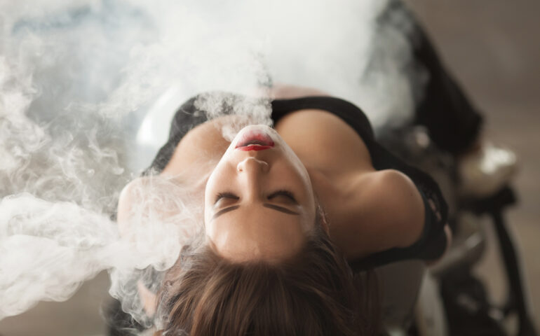 Young beautiful woman vaping