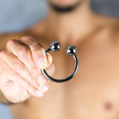 Male torso holding cockring