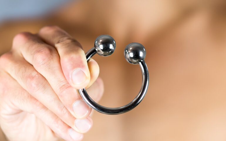Male torso holding cockring