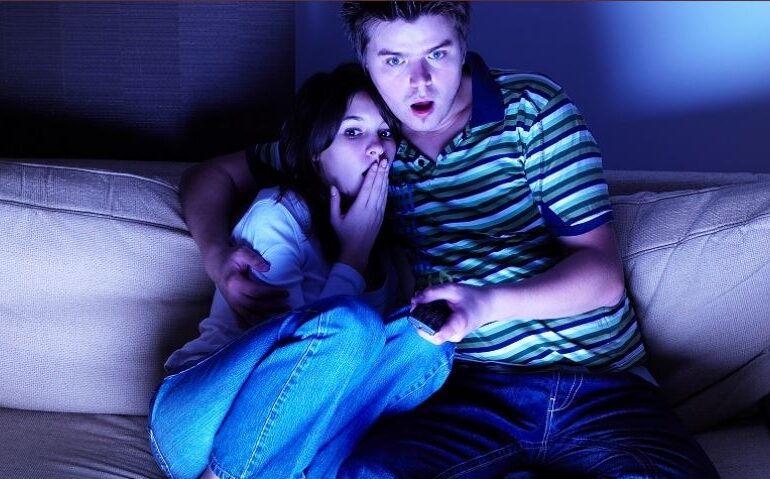 Man and woman watching scary movie