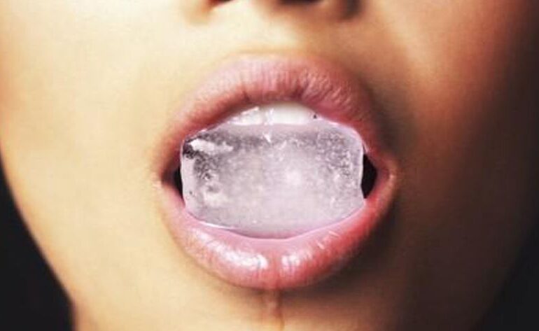 Vrouw met ijsblokje in haar mond