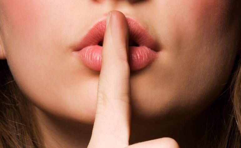 Woman holding her finger on her lips
