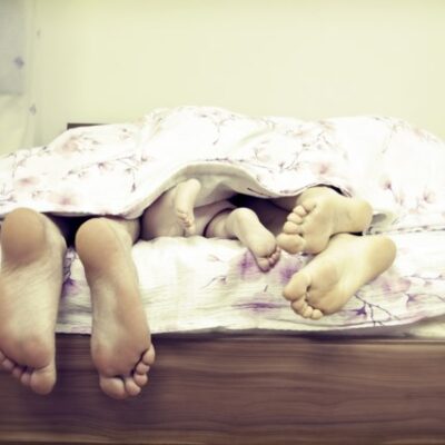 Grote en kleine voeten steken uit bed