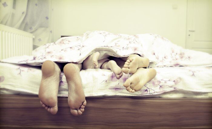 Grote en kleine voeten steken uit bed