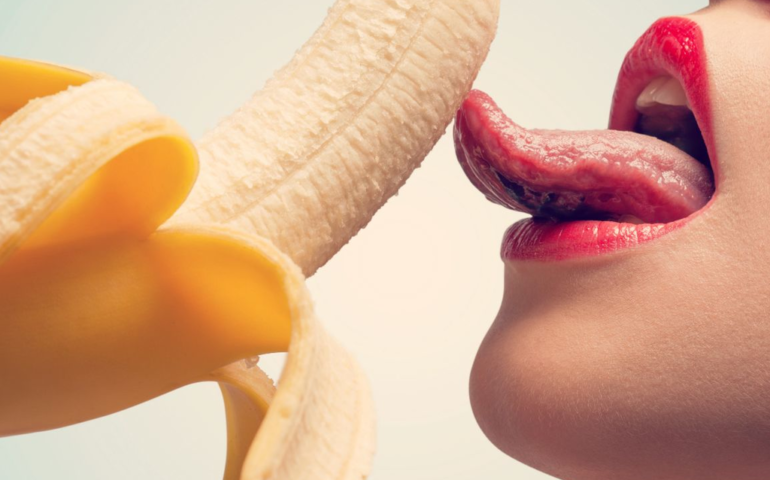 Woman licks a banana