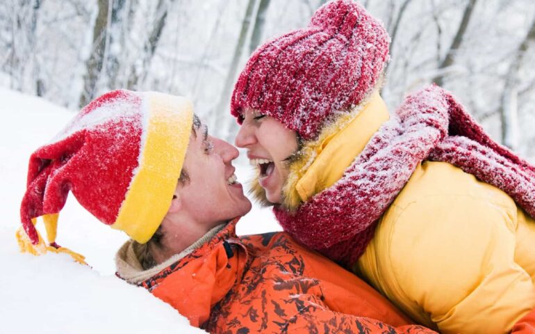 Man en vrouw knuffelen in de sneeuw