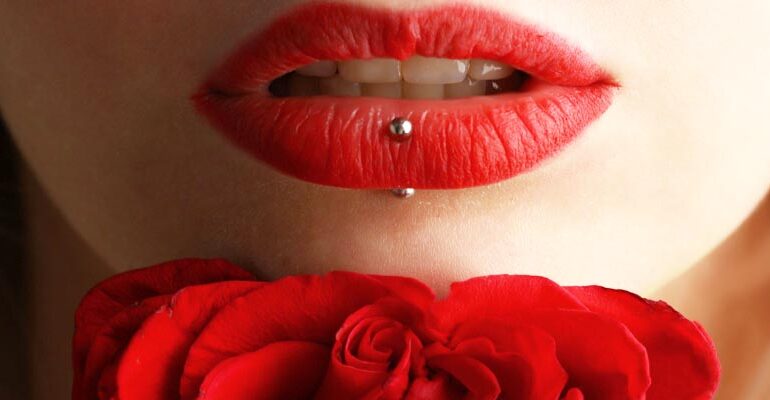Vrouw met rode lippen en rode roos