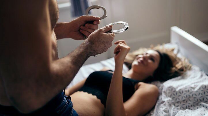 Man holding handcuffs for woman