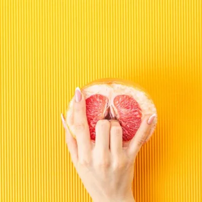 Grapefruit with fingers touching