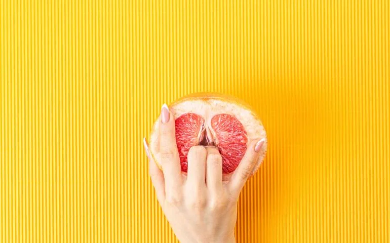 Grapefruit with fingers touching