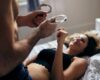 Man houdt handboeien voor zijn vrouw vast